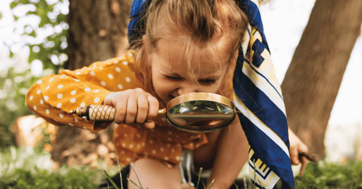 Outdoor Preschool Activities - preschool girl looking through magnifying glass.
