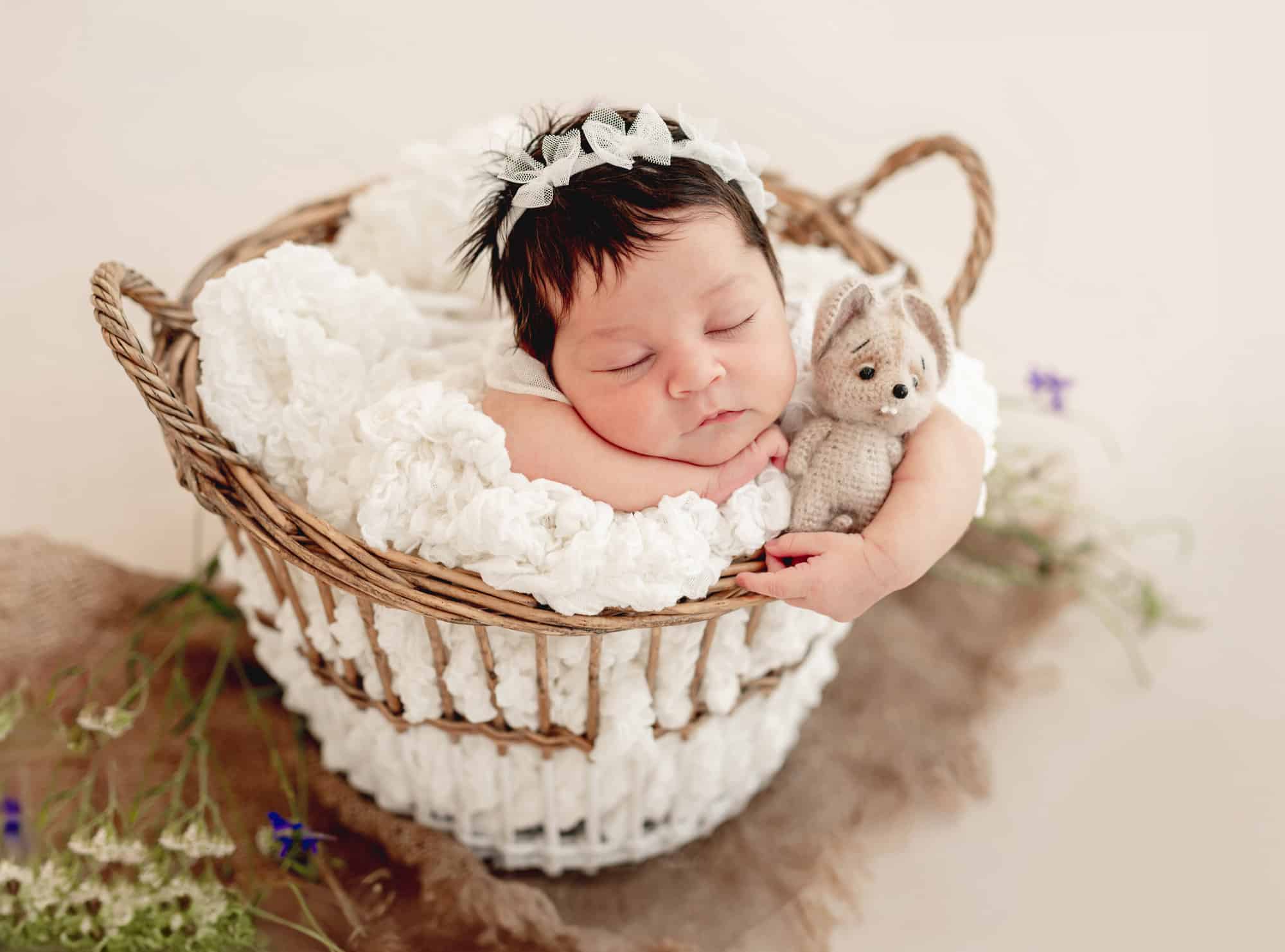 Cute newborn sleeping in basket on stomach