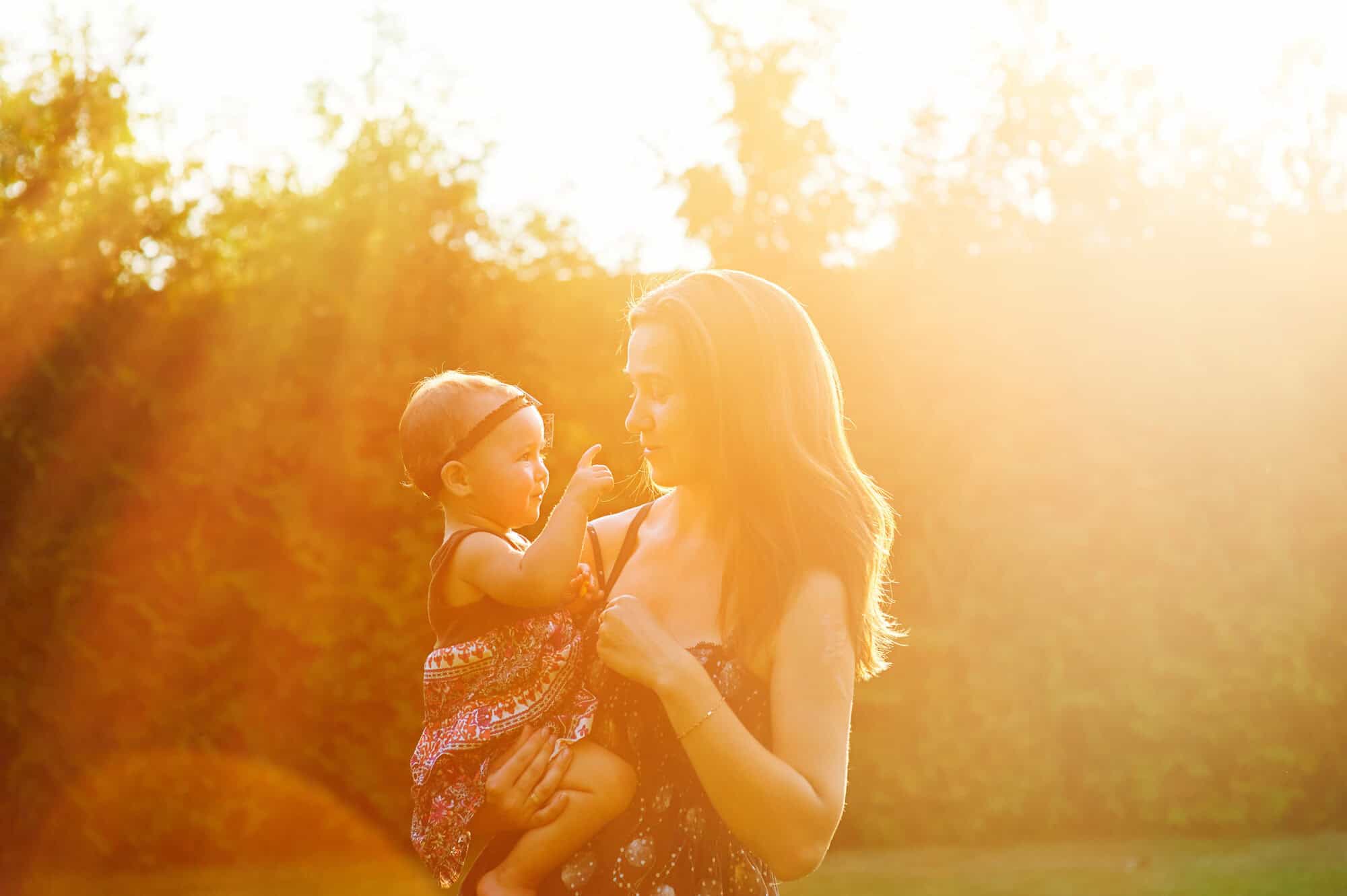 Mother and lovely daughter at sunny park. Happy family concept.
