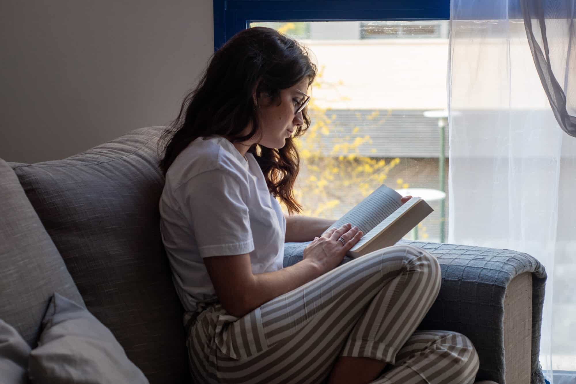 Young woman reading on the sofa
