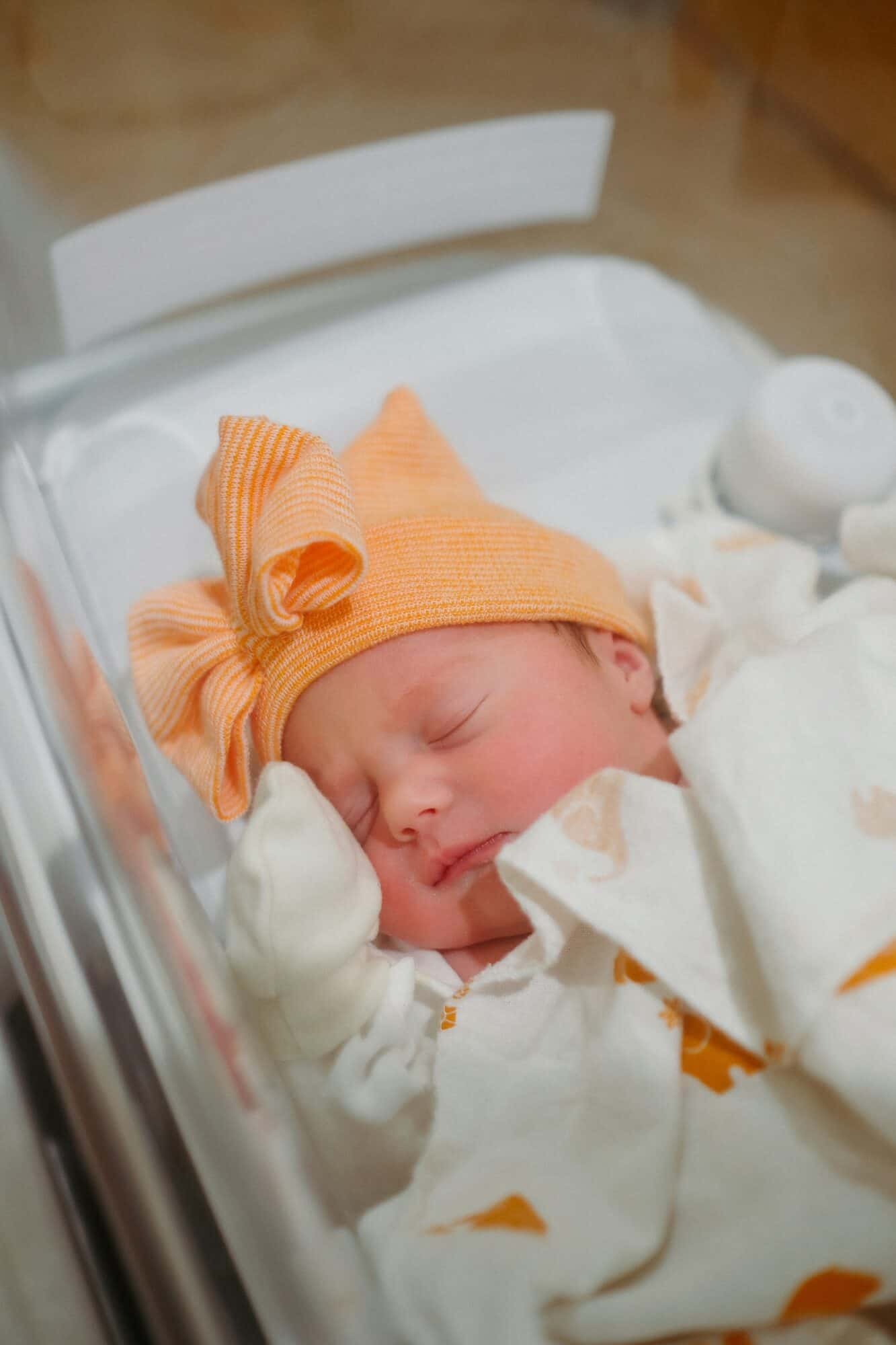 newborn baby in hospital with orange hat