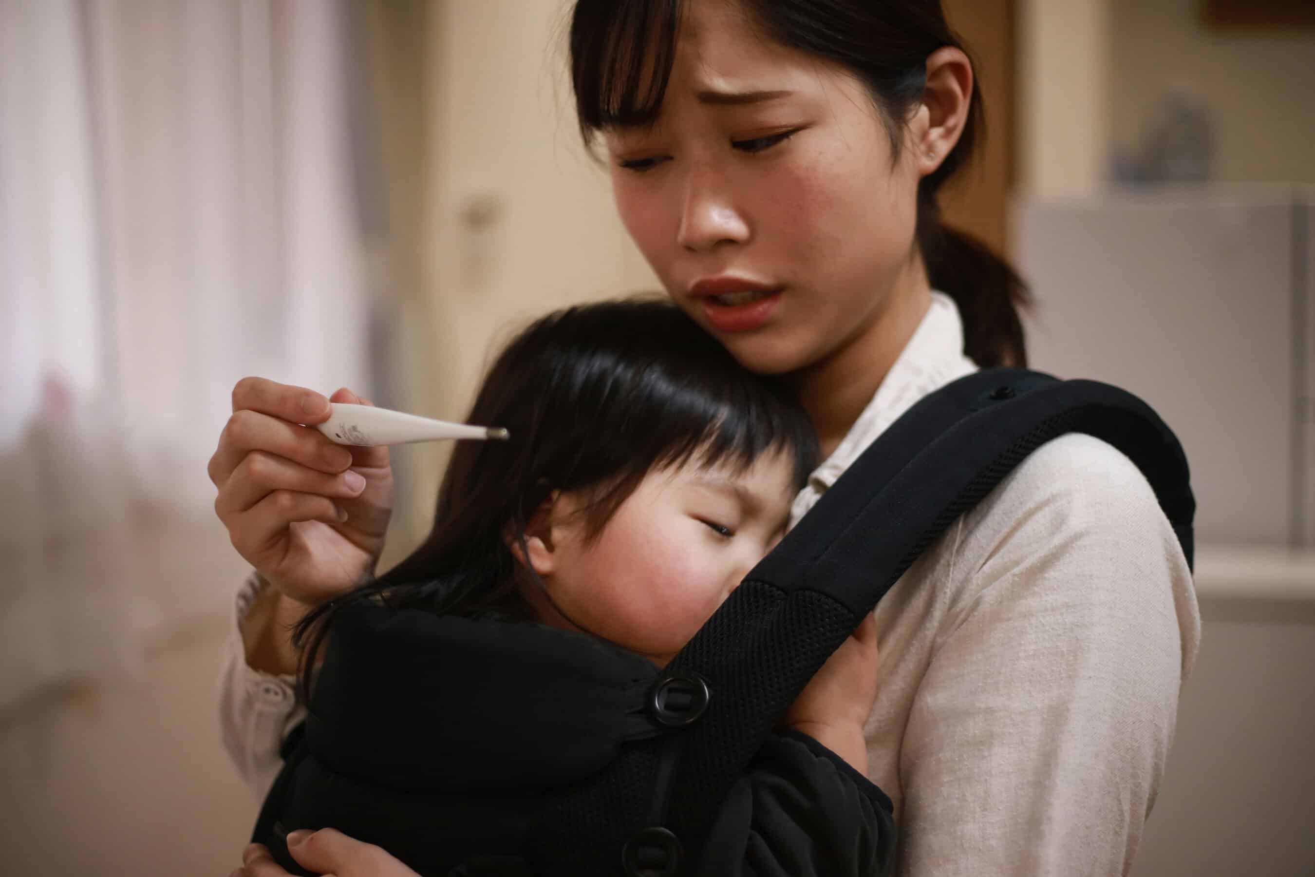 mom looking at digital baby thermometer